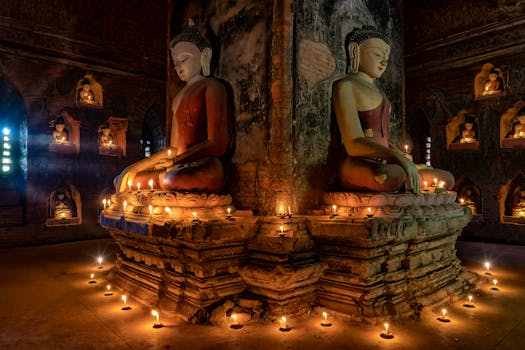 Buddha statues surrounded by candlelight in an ancient temple in Bagan, Myanmar.