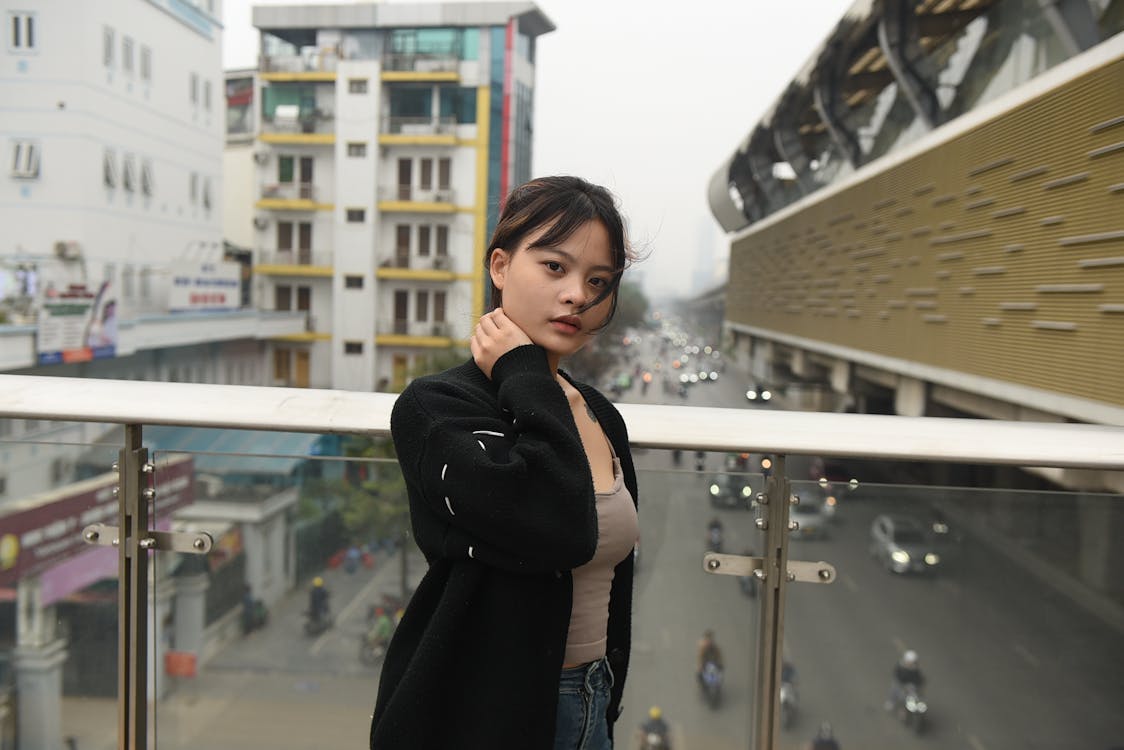 A woman standing on a balcony in a city