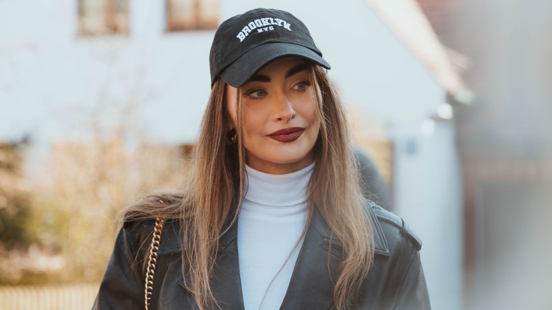 Jeune femme portant une casquette streetwear avec un ensemble complet et un total look urbain