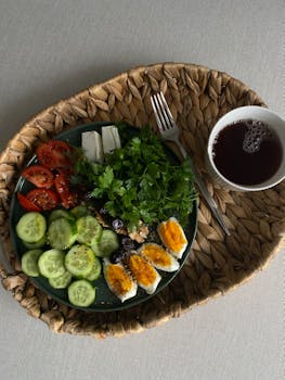 A vibrant breakfast featuring eggs, veggies, and tea on a woven tray.