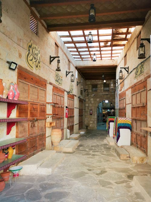 A narrow alley with wooden shelves and doors