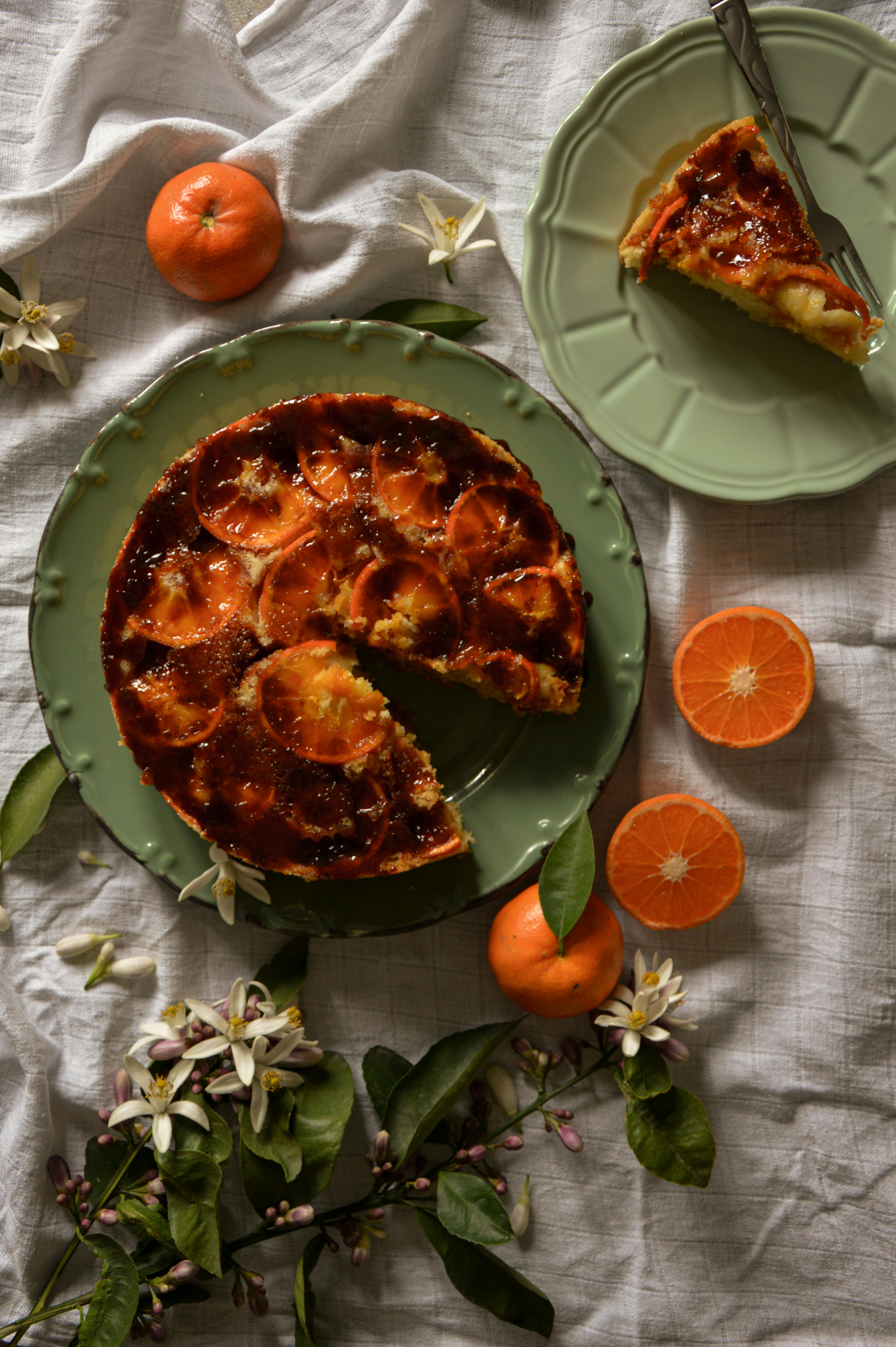 Stylish top view of a tangerine tart with flowers and fruits, ideal for food photographers.