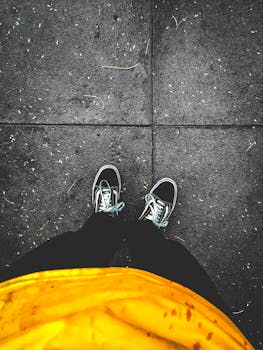 Top-down view of trendy sneakers on wet urban pavement, perfect for street style inspiration.