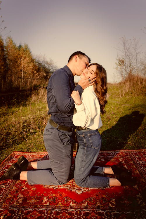 Foto profissional grátis de ajoelhado, beijando, casal