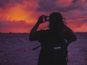 在鲜艳的沙漠日落中，一个人的剪影被拍摄得令人惊叹