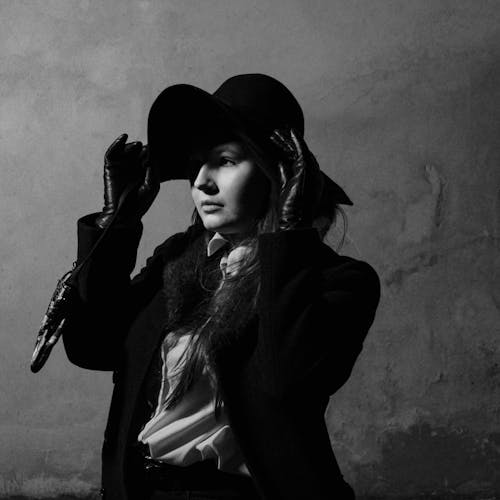 Black and White Photo of a Woman Wearing a Hat 