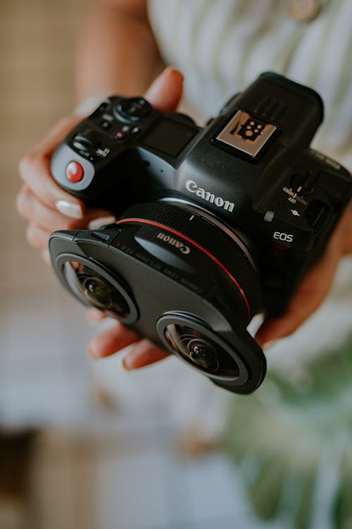 A person holding a camera with two lenses