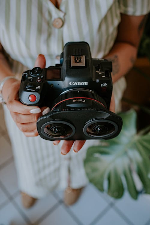 A woman holding a camera with two lenses