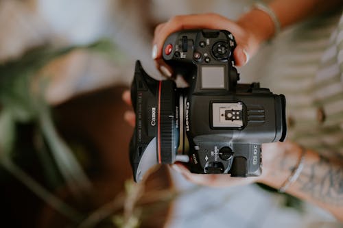 Close-up of a Woman Holding a Canon Camera with a Dual Fisheye Lens