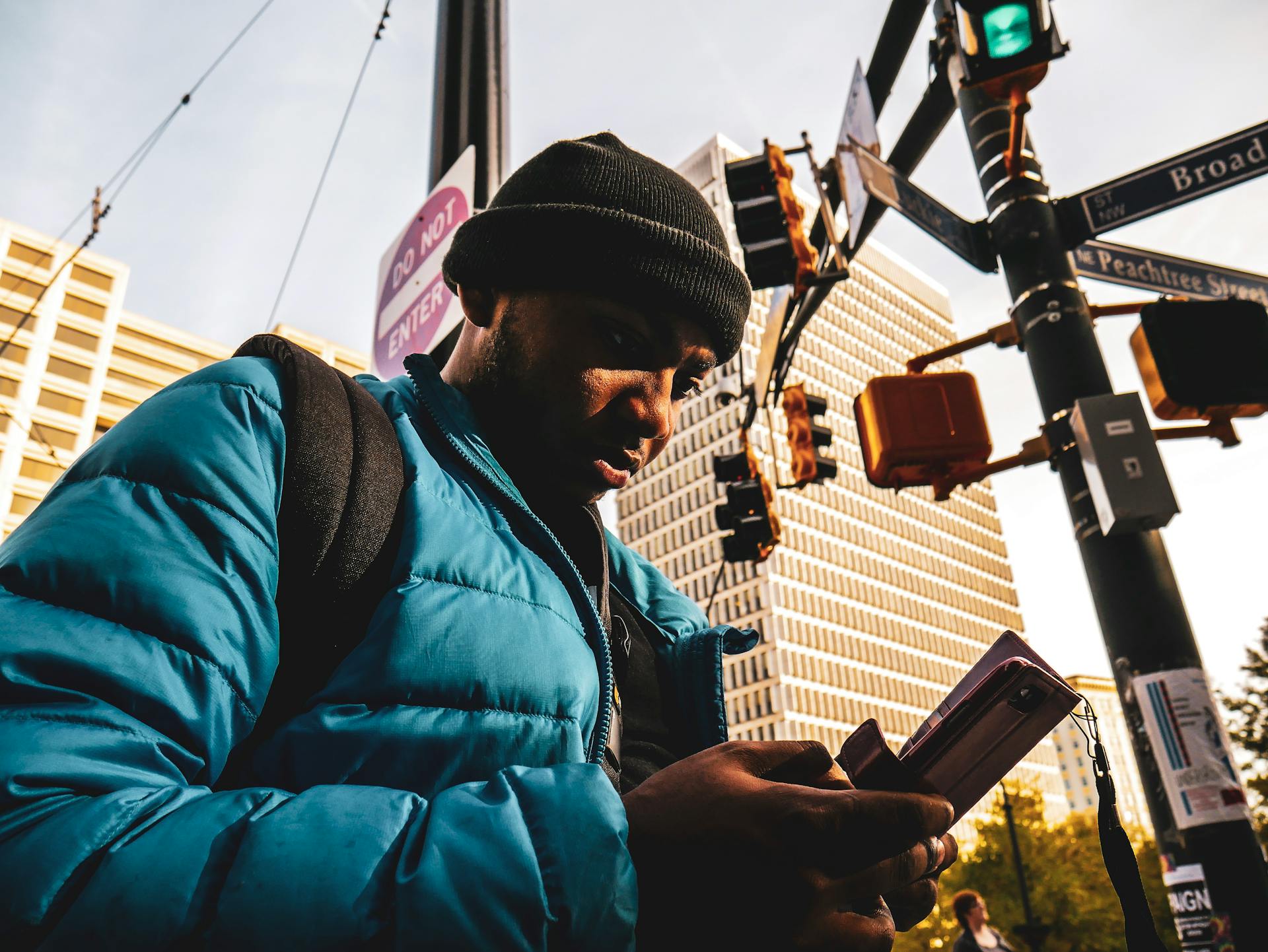 Man Wearing Bubble Zip Jacket Using Smartphone