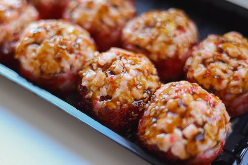 Free Close-up of savory baked sushi balls drizzled with teriyaki sauce, perfect for food photography. Stock Photo