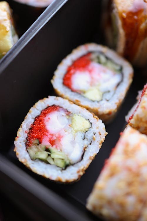 A tray of sushi rolls with different types of food