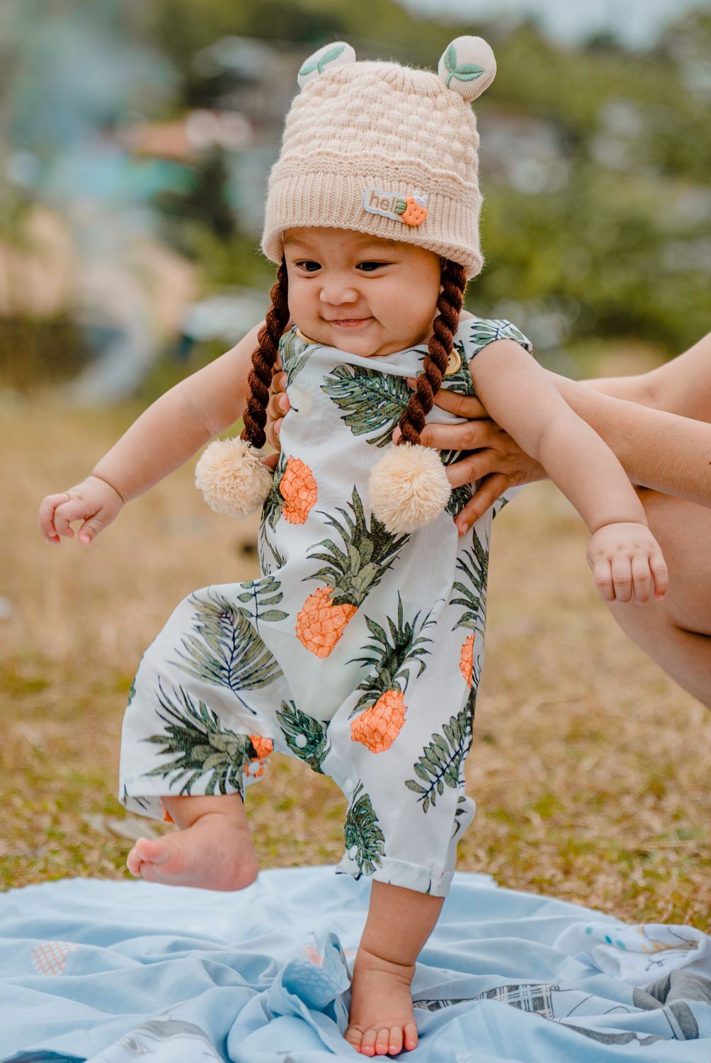 Parent supporting baby to stand — confident and connected at 6–9 months