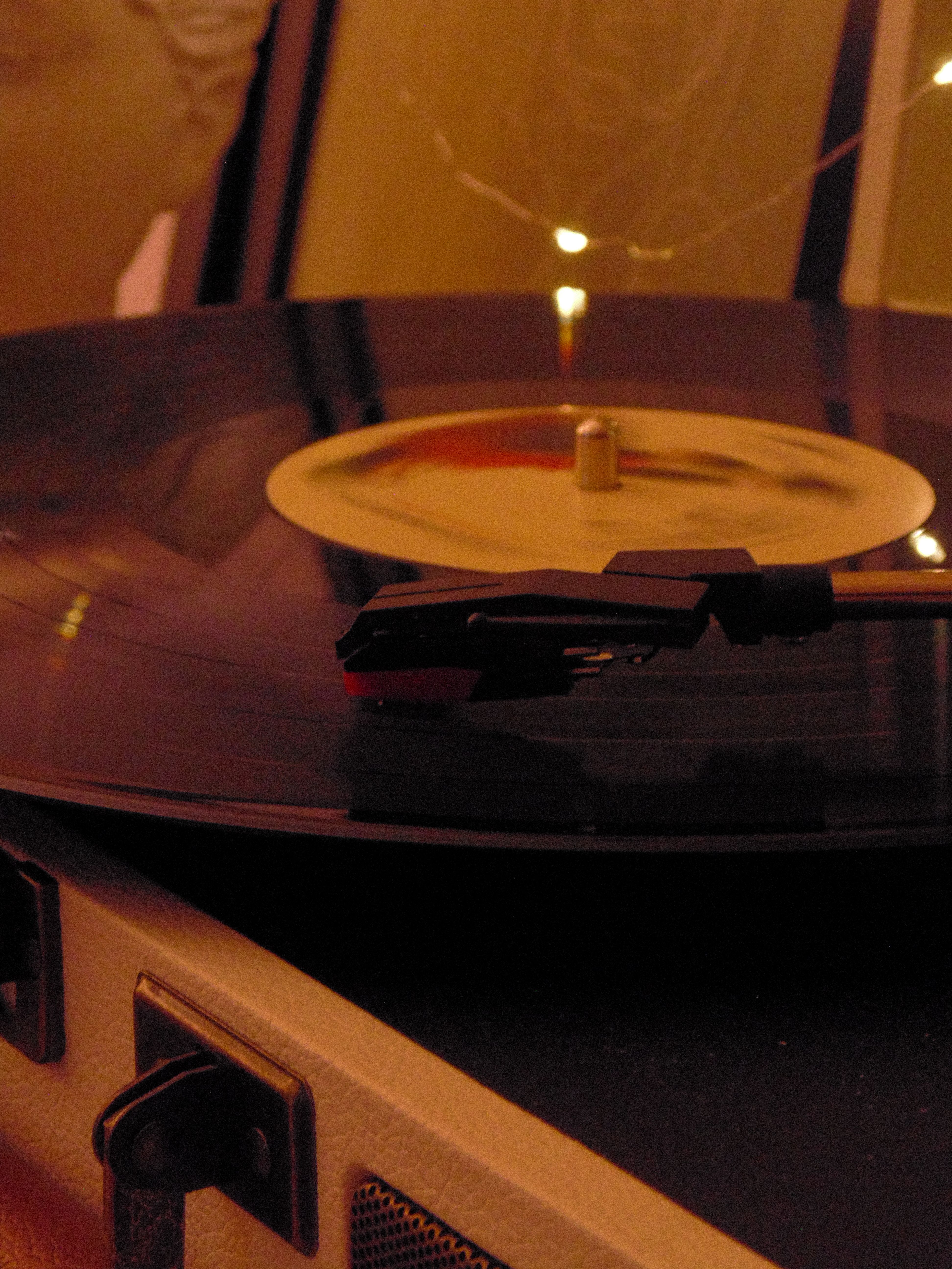 Close-up of a spinning vinyl record on a vintage turntable with warm lighting.