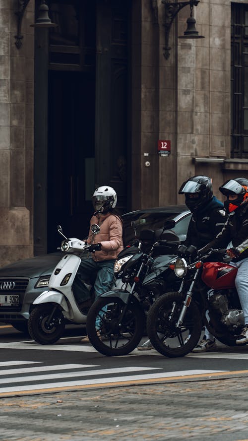 A group of people riding motorcycles on a city street