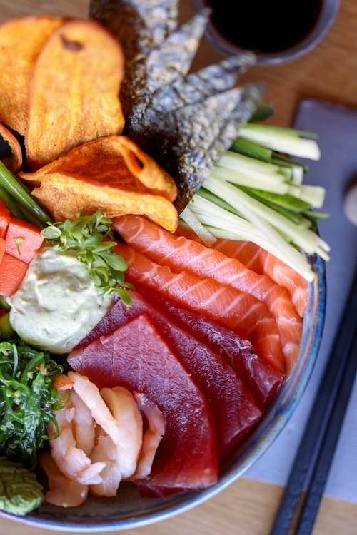 A bowl of sushi with vegetables and other ingredients