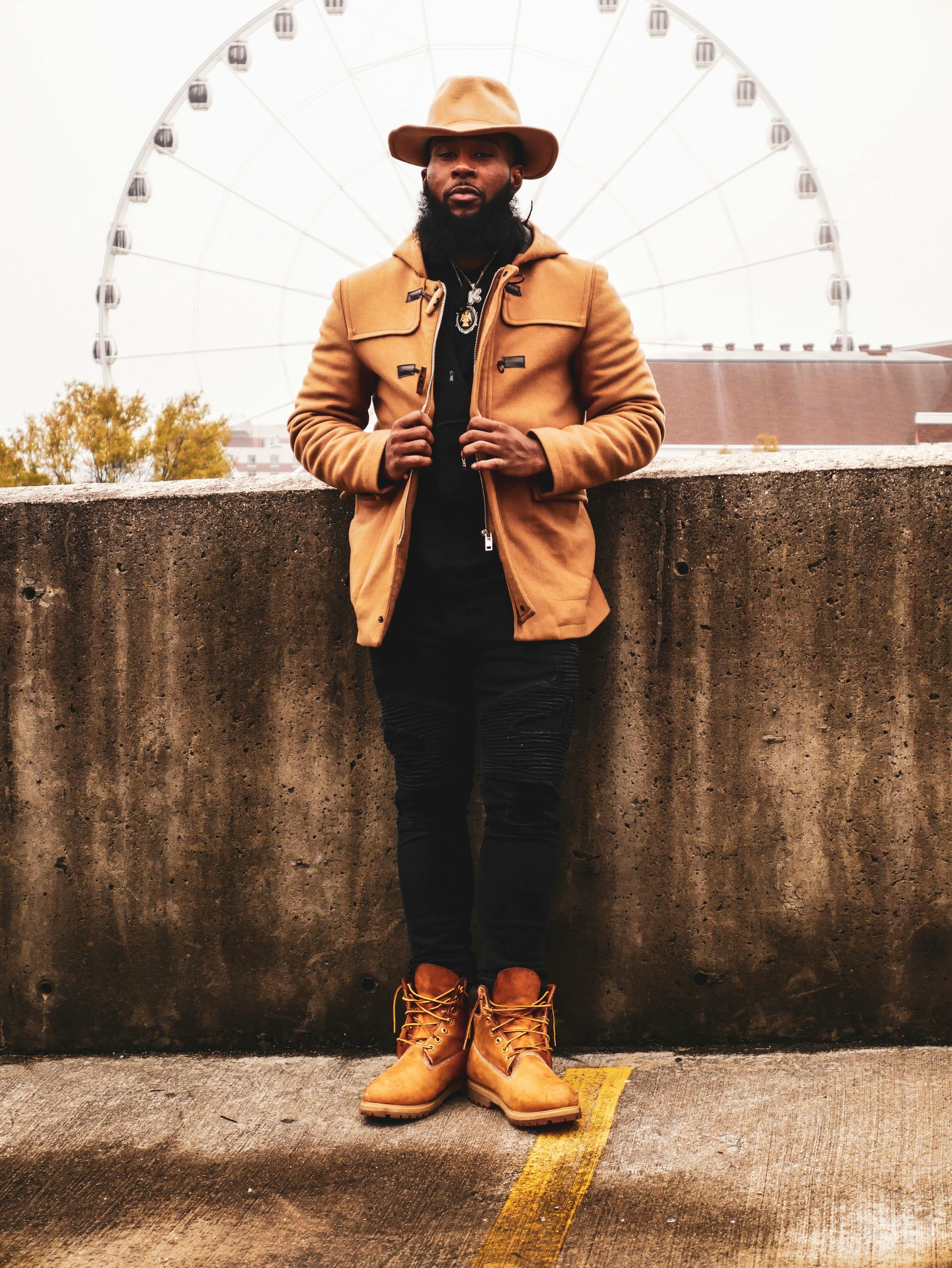 Man Wearing Jacket Leaning on Wall · Free Stock Photo