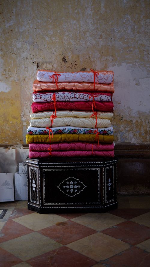 Free A vibrant stack of colorful fabrics displayed in an old rustic setting in Gaziantep, Türkiye. Stock Photo