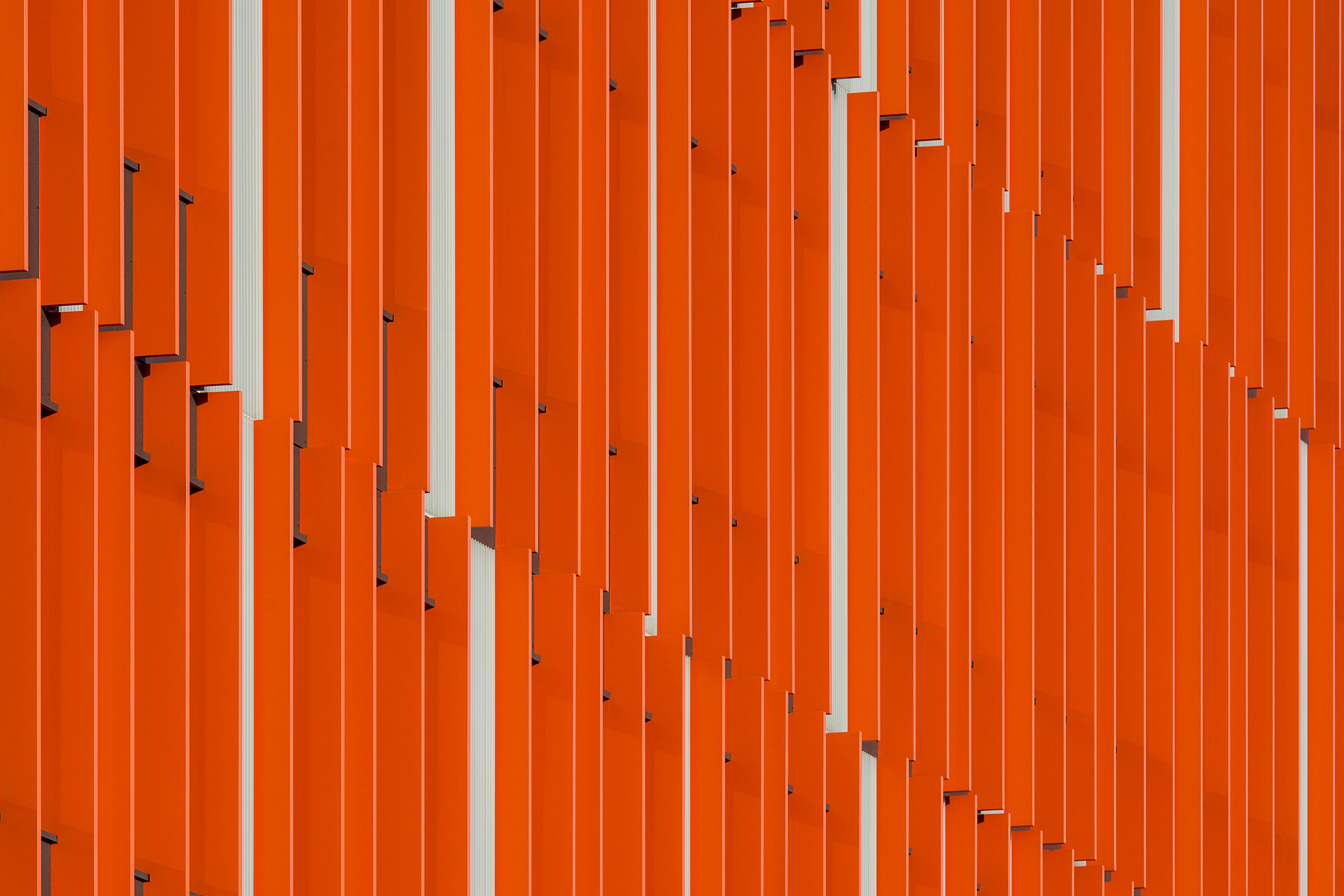 Close-up view of a modern building facade with orange panels creating a vibrant urban pattern in Rotterdam.