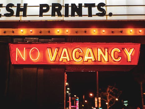 Bright neon 'No Vacancy' sign glowing at night, evoking urban nightlife vibrance.