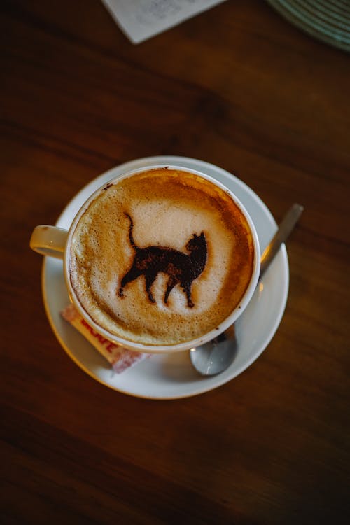 A cup of coffee with a cat drawn on it