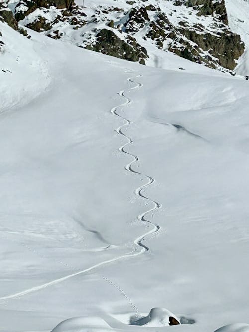 Aerial View of a Winding Trail in Snow in Mountains 