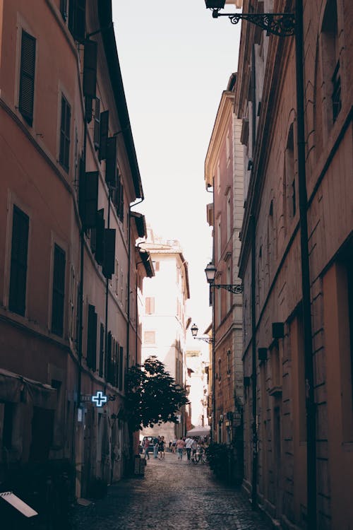 A narrow alley with buildings and people walking