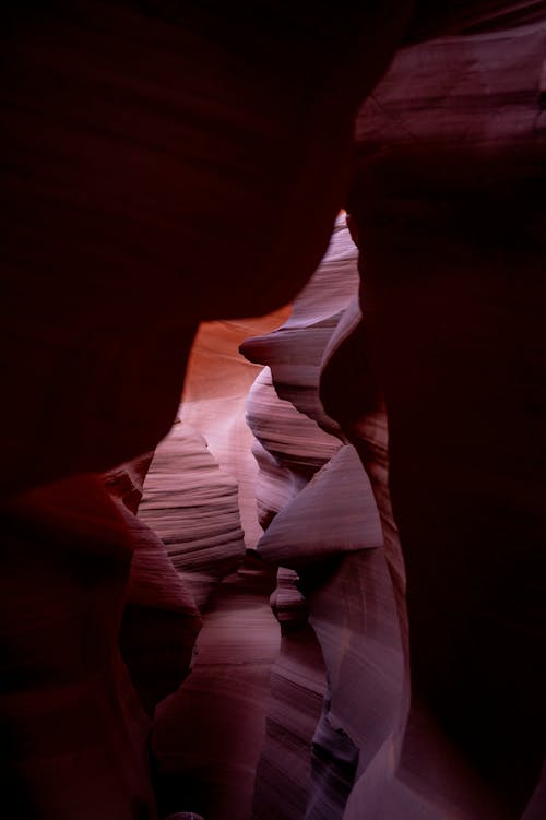 A narrow canyon with red light and dark shadows