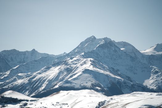Stunning view of snow-covered mountains with crisp winter air against a clear sky.