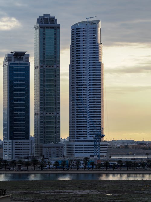 Two tall buildings are sitting next to a body of water