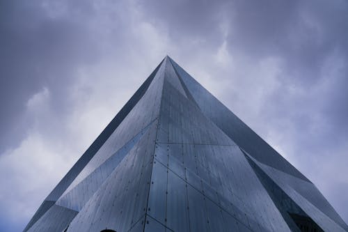 A tall building with a cloudy sky above it