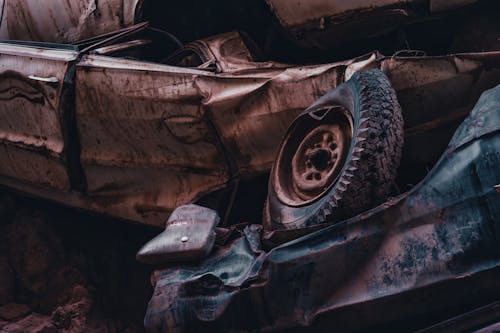 An old car is sitting in the dirt