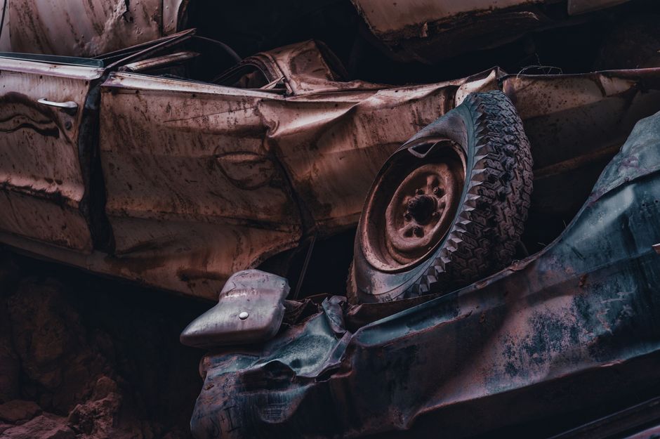 Rows of old vehicles in a salvage yard where scrap values are compared