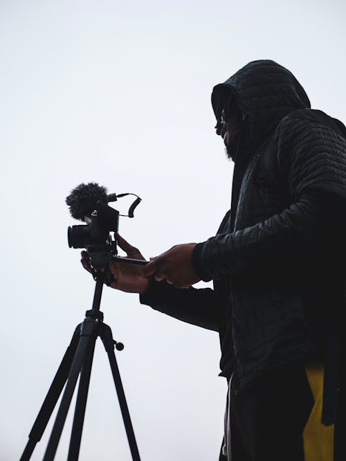 Person Holding Camera on Tripod