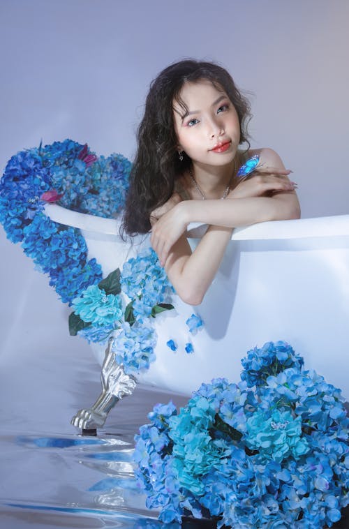 A woman in a bathtub with blue flowers