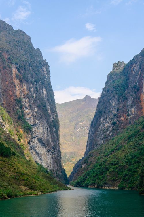 Free A breathtaking view of a serene river winding through a towering canyon under a clear blue sky. Stock Photo