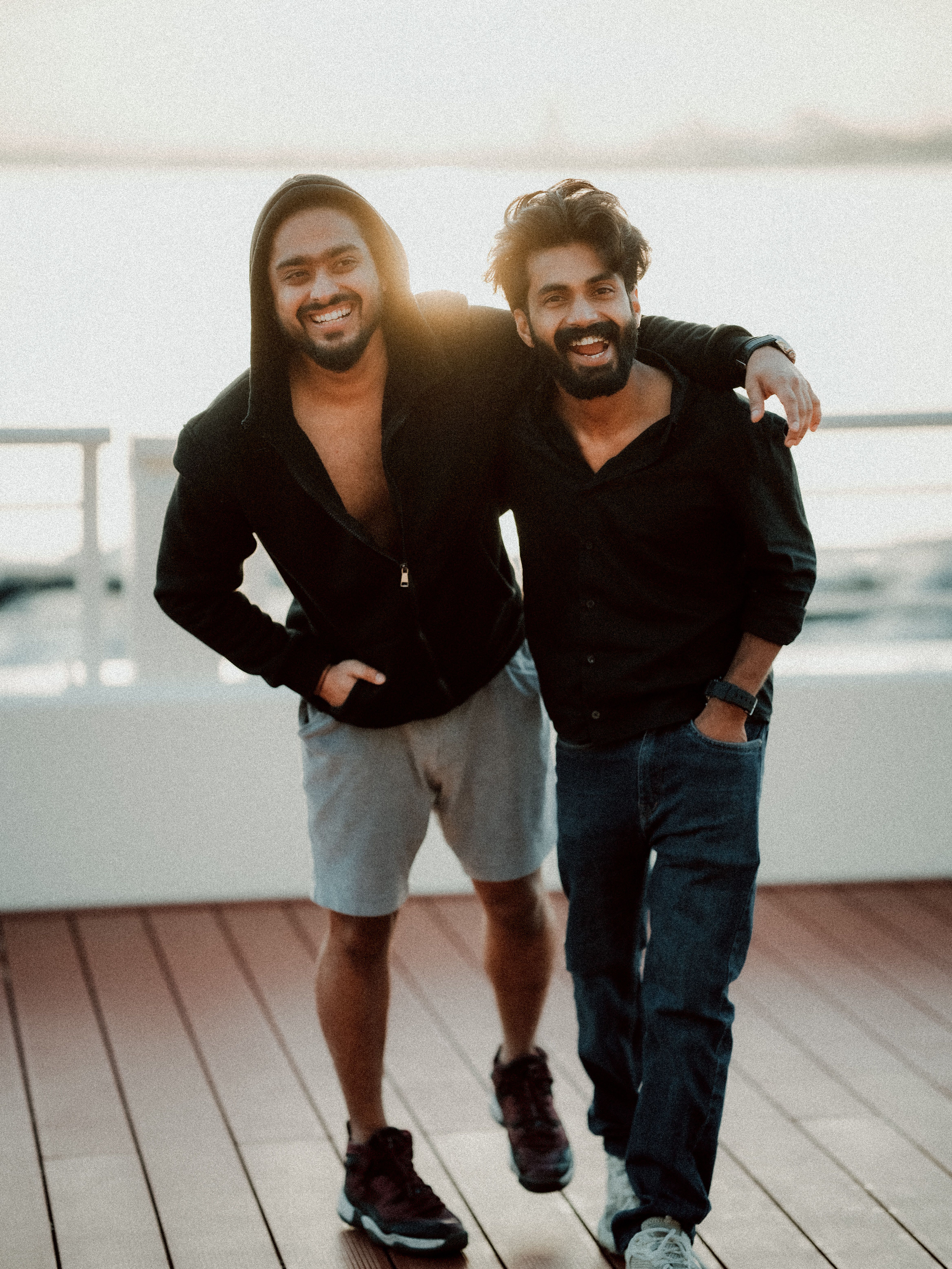 Two friends smiling at sunset on a yacht deck in Dubai. Perfect vacation vibes.
