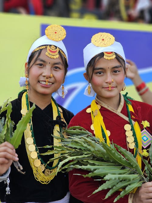 Two girls in traditional dress holding flowers