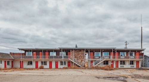 An empty motel with stairs leading up to the building