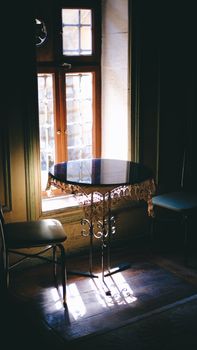 Vintage café table by a sunlit window in Gaziantep, Türkiye. Warm, inviting atmosphere.