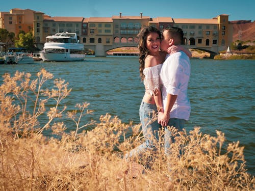 Free Man and Woman Standing Near Body of Water Stock Photo