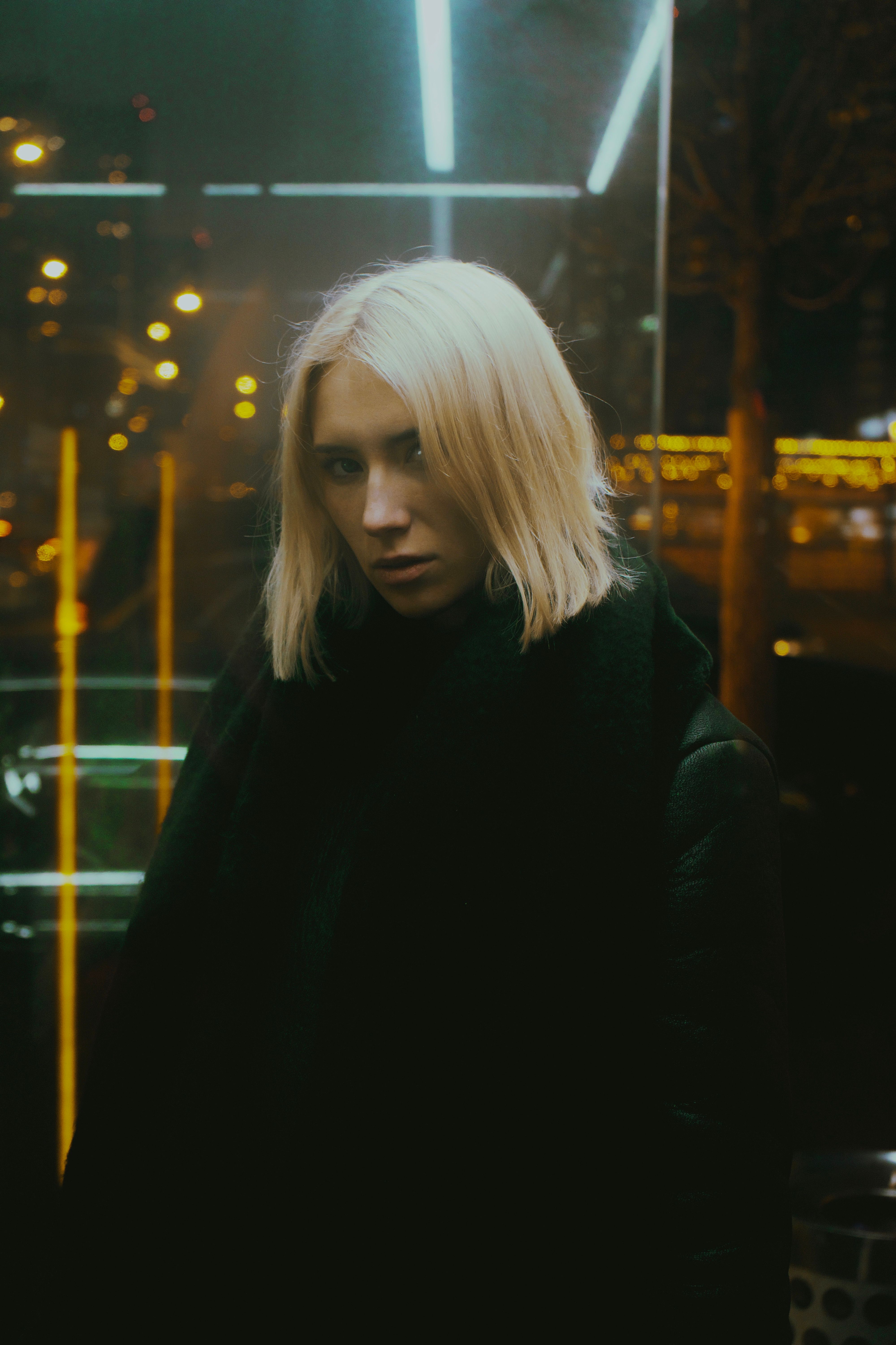 Young Woman in a Black Jacket Standing in City at Night · Free Stock Photo