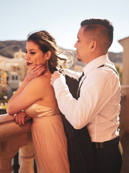 Shallow Focus Photo of Man Putting Black Jacket on Woman