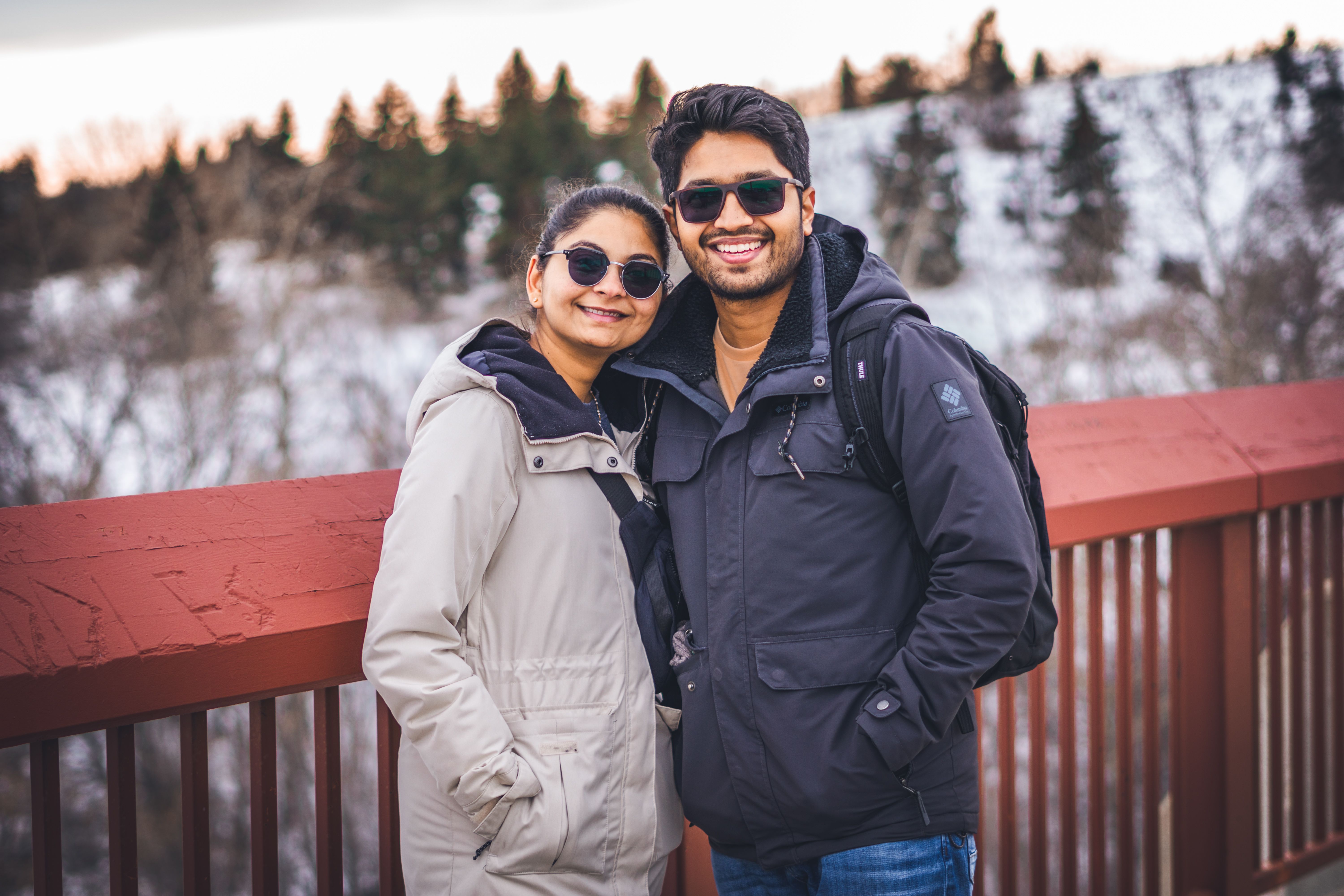 Happy couple enjoying a walk on a snowy bridge in winter clothing