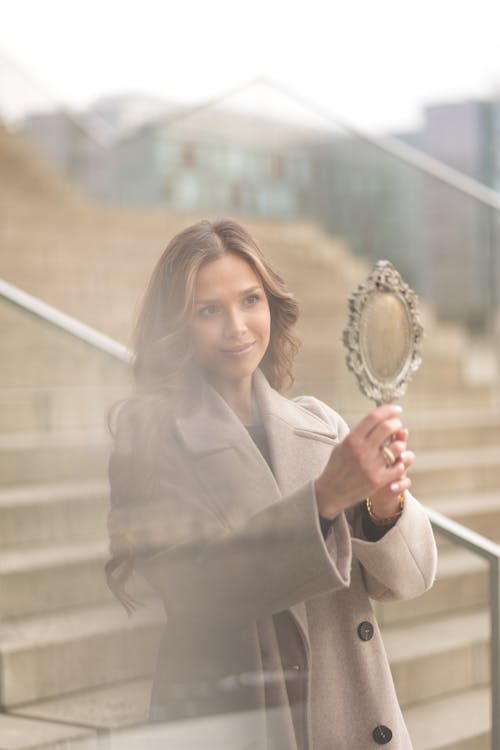 A woman is holding a mirror in front of her