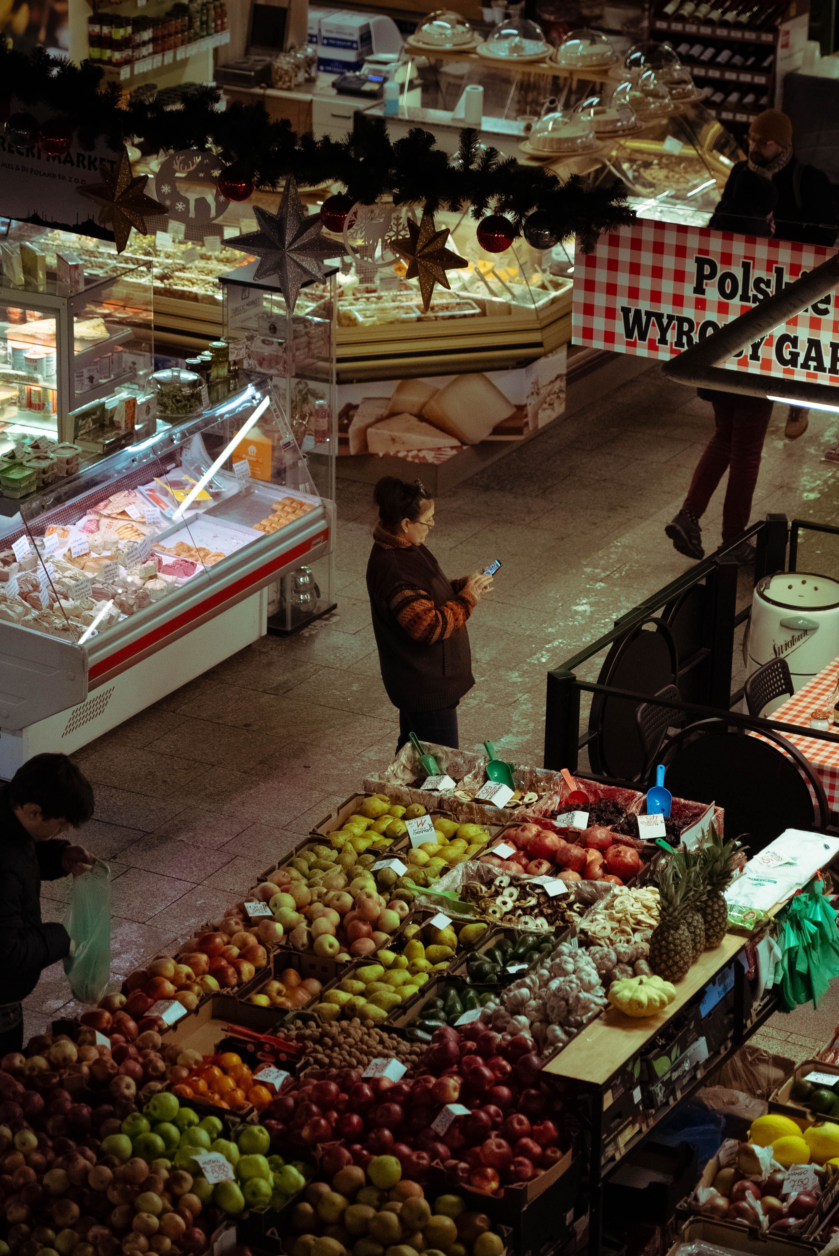 A bustling indoor market in Wrocław filled with diverse fruits and merchandise, capturing local culture.