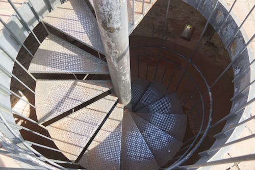 A spiral staircase in a building with metal bars