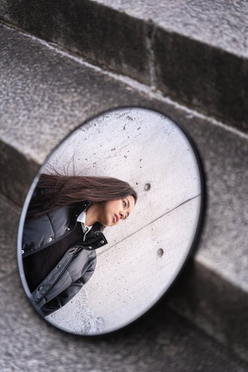 A woman is looking at herself in a mirror