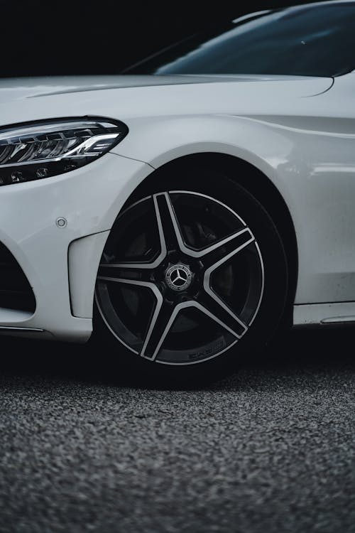 The front wheel of a white mercedes car