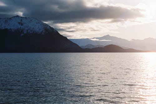 A body of water with mountains in the background